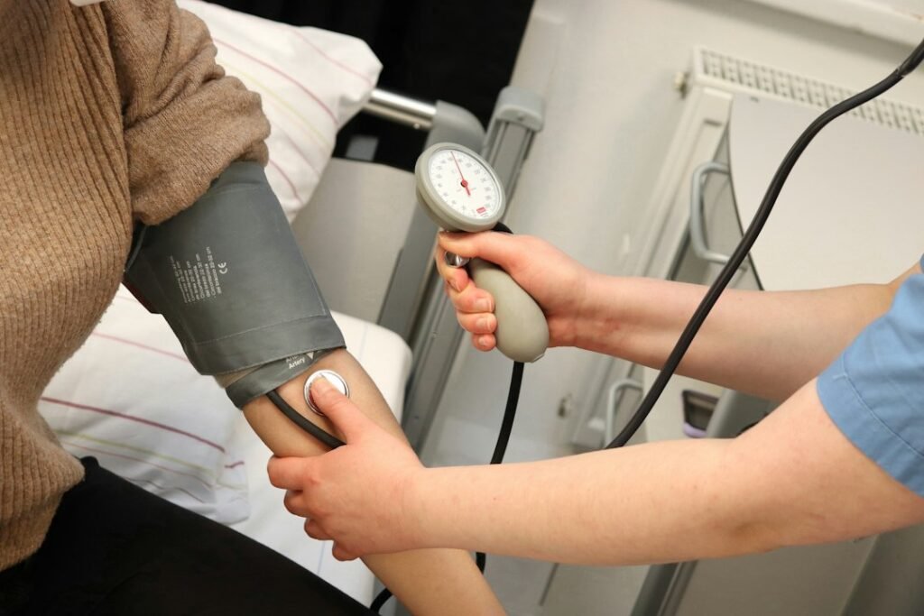 Person using a blood pressure monitor during medication follow-up