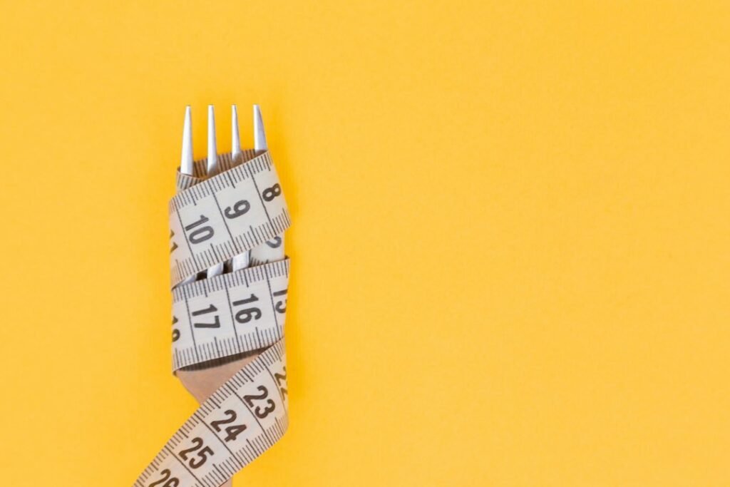 Measuring tape and fork representing a gradual semaglutide weight loss timeline