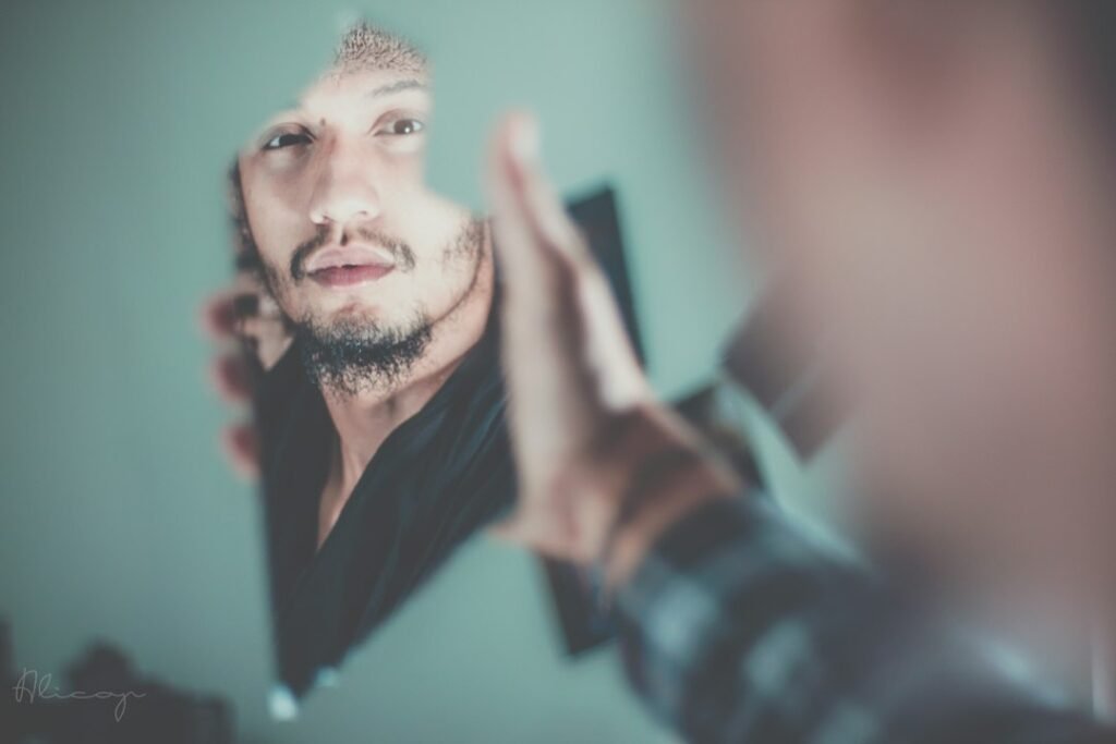Man looking in a mirror while considering changes to his hairline